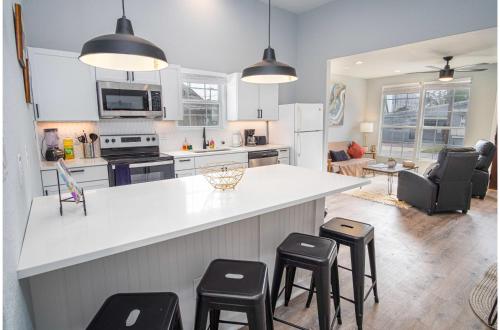 a kitchen with a white counter and stools at Charming 3BR2BA Gem Close to Downtown Riverwalk in San Antonio