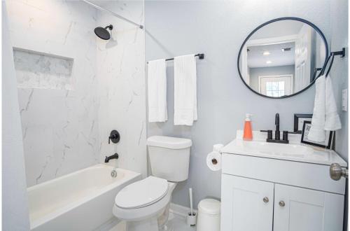 Baño blanco con lavabo y espejo en Charming 3BR2BA Gem Close to Downtown Riverwalk, en San Antonio