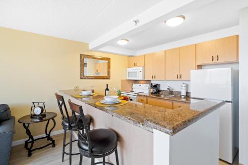 a kitchen with a counter and chairs in a room at Stunning Mountain View Condo, Near Beach with Parking in Honolulu