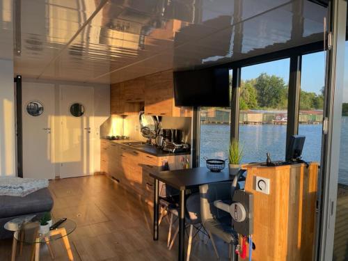 cocina y sala de estar con mesa en un barco en Führerscheinfreies mobiles Hausboot en Rechlin