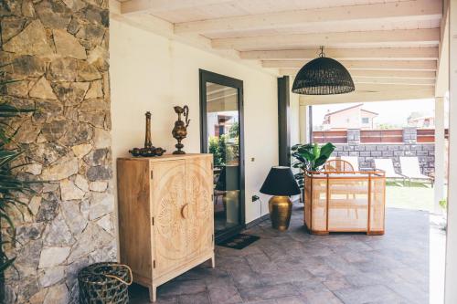 a room with a wooden cabinet and a stone wall at Eksōtika in Oliveri