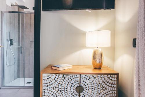 a lamp on top of a wooden table in a bathroom at Eksōtika in Oliveri