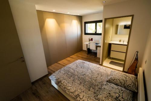 um quarto com uma cama, um lavatório e um espelho em SUD VILLA DE LUXE - PLAGES - PISCINE - JACUZZI - Jeux Olympiques 2024 em Lattes