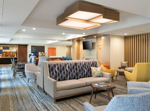 a waiting room with a couch and chairs at Holiday Inn Express Indianapolis Airport by IHG in Plainfield