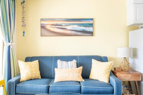 a blue couch with pillows in a living room at GypSEA Blu Beach Condo Steps to the Beach in Galveston