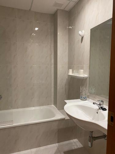 ein Badezimmer mit einem Waschbecken, einer Badewanne und einem Waschbecken in der Unterkunft Hotel Agrelo in Reboredo