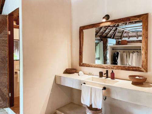 a bathroom with a sink and a mirror at Amansala Resort in Tulum