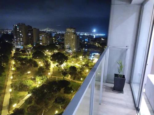 a balcony with a view of a city at night at Barranc Group Penthouse in Lima