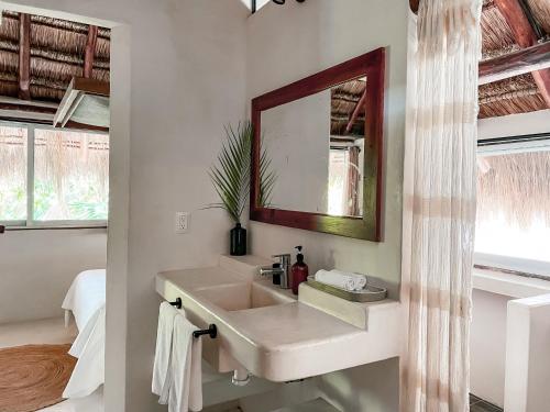 a bathroom with a sink and a mirror at Amansala Resort in Tulum