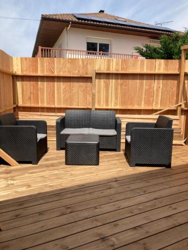 une terrasse en bois avec 2 chaises et une table. dans l'établissement Appartement cosy avec grande terrasse, à Mimizan