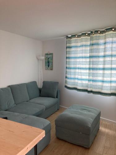 un salon avec un canapé et une table dans l'établissement Appartement cosy avec grande terrasse, à Mimizan
