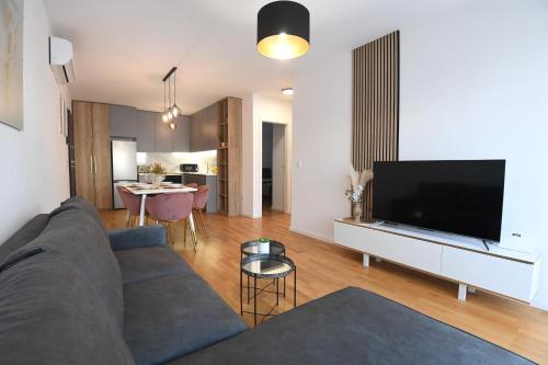 een woonkamer met een bank en een flatscreen-tv bij Garden apartment Leoma with free parking! in Zadar