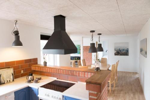 セビーにあるFeriehuset - Lille Vikingの青いキャビネットと黒いペンダントライト付きのキッチン