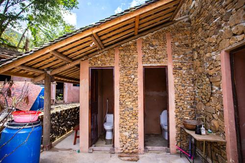 a stone building with a toilet on the side of it at Dinh Đá H'Mông - Karsterly Rock Lodge in Dồng Văn