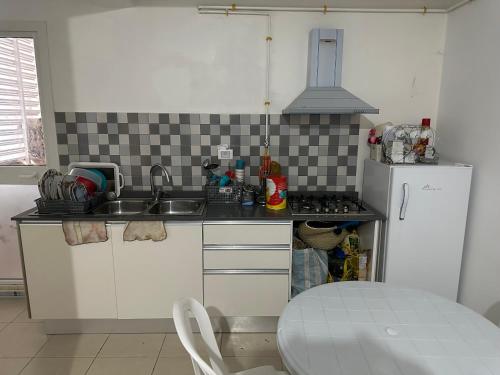 Harqalah的住宿－Sousse Beach luxe，厨房配有白色橱柜、水槽和冰箱。