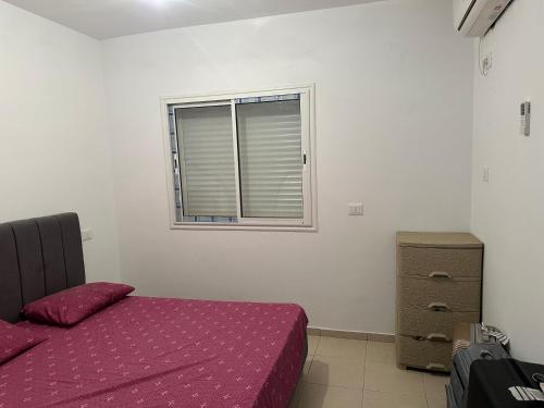 ein Schlafzimmer mit einem lila Bett und einem Fenster in der Unterkunft Sousse Beach luxe in Harqalah