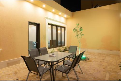 uma sala de jantar com mesa e cadeiras em شاليهات ريفي em Riyadh