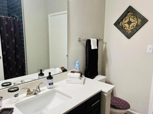 y baño con lavabo, aseo y espejo. en Modern Gem: 2BD/2BA Oasis in Shadowbriar, Houston!, en Houston