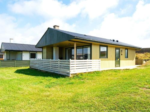 a yellow house with a black roof on a grass field at 6 person holiday home in Lemvig in Trans