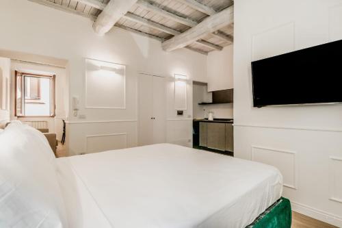 a white bedroom with a bed and a flat screen tv at APT ROME - Vittoria Palace in Rome