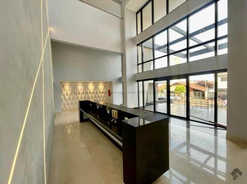 una grande stanza con un tavolo e alcune finestre di Loft de Luxo c/ Home Office ao lado Shopping CG. a Campo Grande