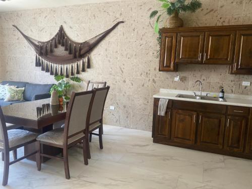 a kitchen with a table and chairs and a sink at Ancla Suite 2 - 2 Bedroom Urban Hotel in Puerto Peñasco