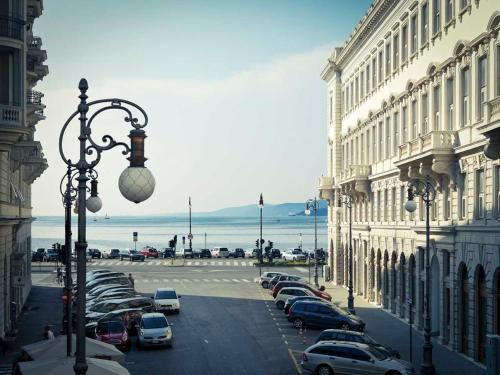 a parking lot with cars parked in front of buildings at Hotel Vis à Vis in Trieste