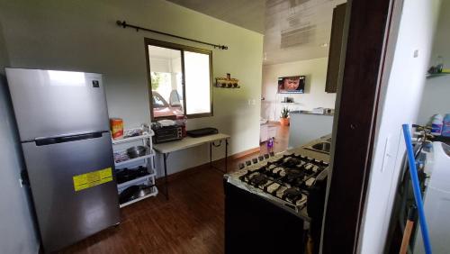 a kitchen with a refrigerator and a stove top oven at Vistaverdeboquete in Boquete