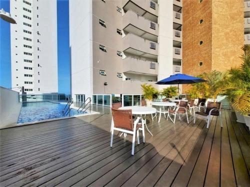 una terraza con mesas y sillas y una piscina en Marina Bezerril - 303 Pontamares - O melhor de Natal, en Natal
