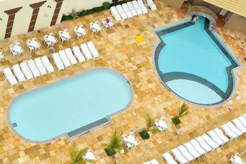 una vista aérea de una piscina con mesas y sillas en Via Caldas Exclusive, en Caldas Novas