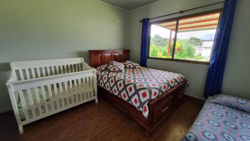 een slaapkamer met 2 aparte bedden en een raam bij Vistaverdeboquete in Boquete