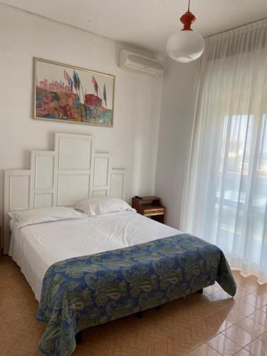 a bedroom with a large white bed and a window at Hotel Laguna in Lido di Jesolo