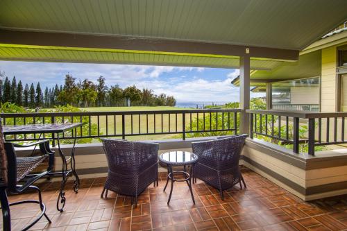 a porch with chairs and tables and a view of the ocean at Kapalua Villas Maui - Select Your Unit in Kahana