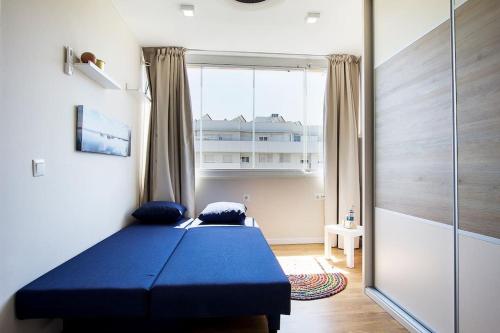 una camera con un letto blu e una finestra di Great location! Walking distance to everything! a Fuengirola
