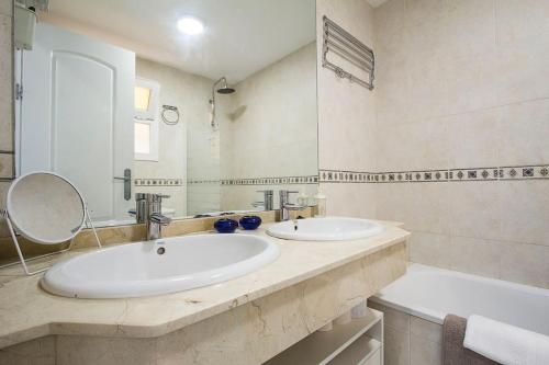 a bathroom with two sinks and a large mirror at Great location! Walking distance to everything! in Fuengirola