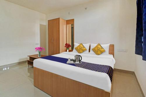 um quarto com uma cama grande e um lavatório em SPOT ON 70112 Sri Saptagiri Bording Lodging em Bangalore