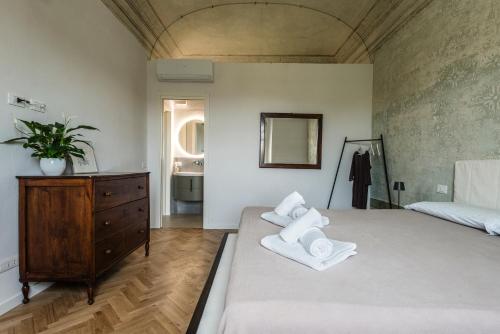 a bedroom with a large bed with towels on it at La Camera Verde in Pisa