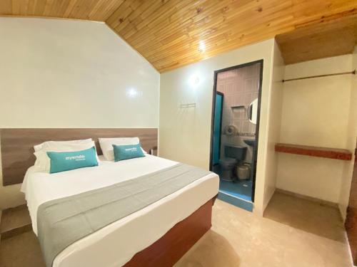 a bedroom with a large bed and a bathroom at Ayenda Alfay Mosquera in Mosquera