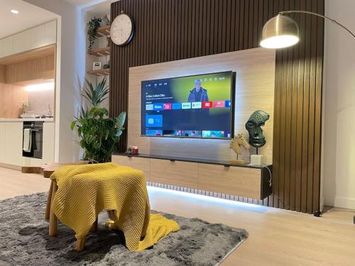 een woonkamer met een grote televisie en een tafel bij 2Brooms Max for5 at Heart of CBD 1Free Parking in Melbourne