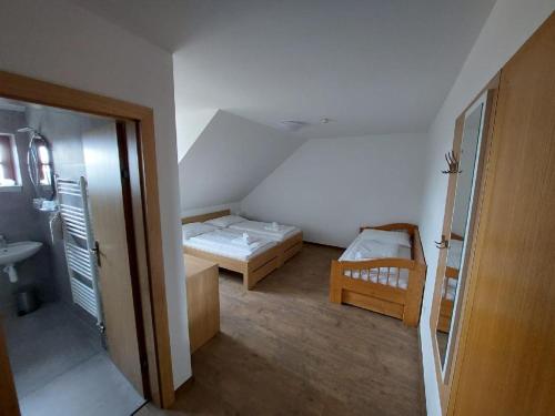 mały pokój z 2 łóżkami i umywalką w obiekcie Horský hotel Hájenka w Makowie