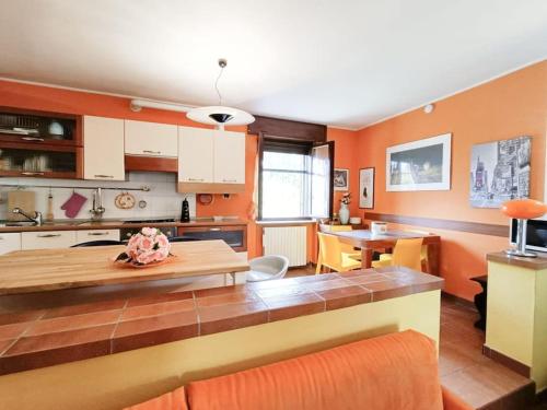 uma cozinha com paredes cor de laranja e uma sala de jantar em [Oltrepo'] Dimora nei vigneti vicino a Ics Maugeri em Santa Maria della Versa