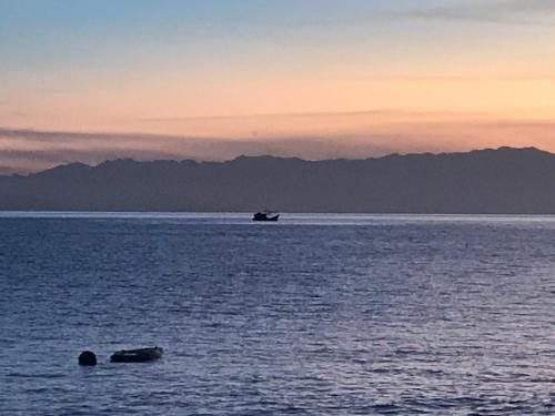 a boat in a large body of water at sunset at Cabana do Mar in Angra dos Reis