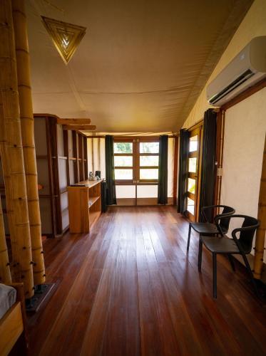 an empty room with a wooden floor and chairs at Houttuyn Wellness River Resort in Paramaribo