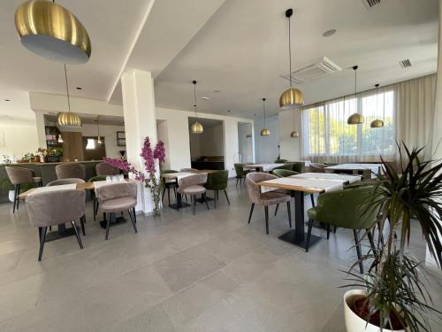 a restaurant with tables and chairs and plants at MEMORI bed&breakfast in Rab