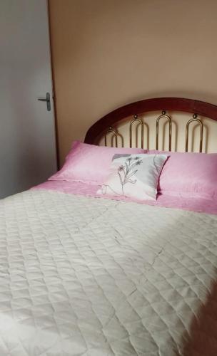 a white bed with pink sheets and a white pillow at Casa do Mirante in Petrópolis