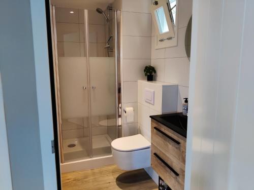 a bathroom with a shower and a toilet and a sink at Park De Driesprong in Nieuwveen