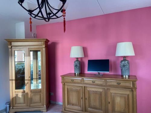 two lamps on top of a wooden cabinet in a room at No Bathroom B&B in Aalten