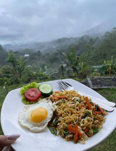 a plate of food with an egg and noodles at Wanagiri Campsite in Gitgit