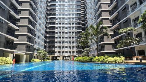 a large apartment building with a large swimming pool at Shore 3 Tower 1 MOA Pasay F Suite Staycation in Manila