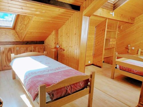 a bedroom with a bed in a wooden cabin at Gîte confortable à La Bresse, proche centre-ville, nature et activités - FR-1-589-97 in La Bresse